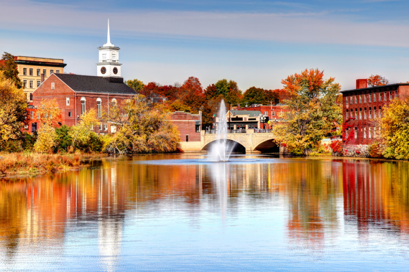 Beautiful Colonial buildings reflecting off a lake in the fall.