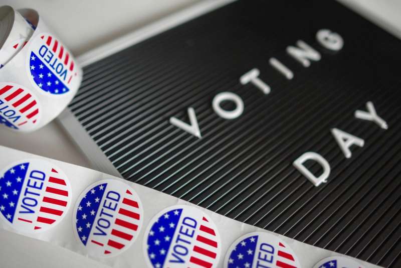 Vote stickers next to a Voting Day sign.