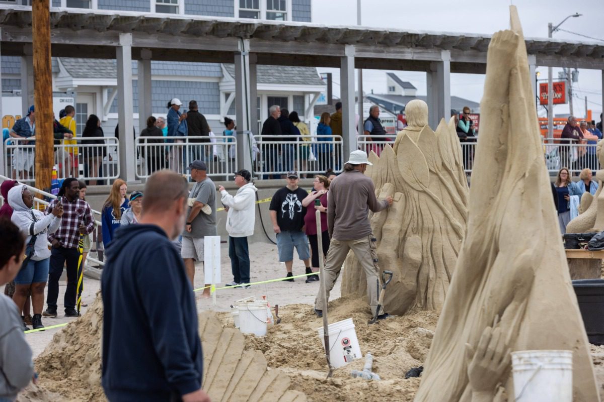 person watches the sculpting at the Hampton Beach Sand Sculpting Classic