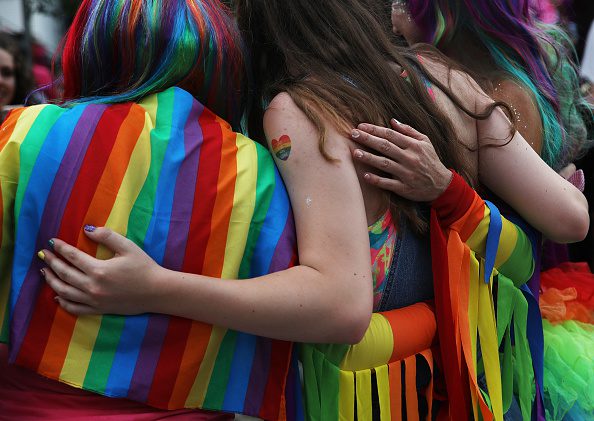 People embrace for a photo while attending a pride festival that took place after the Nashua Pride parade in Nashua, NH