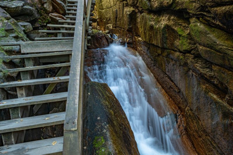 a wooden walkway beside a waterfall and gorge
