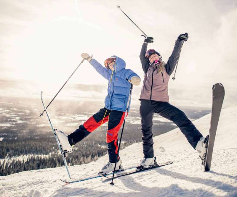 New Hampshire stereotypes; two children dance on skis atop a mountain